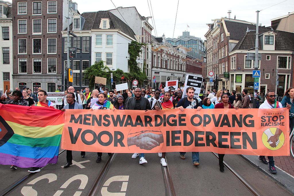 mensen marsen met spandoek menswaardig opvang voor iedereen