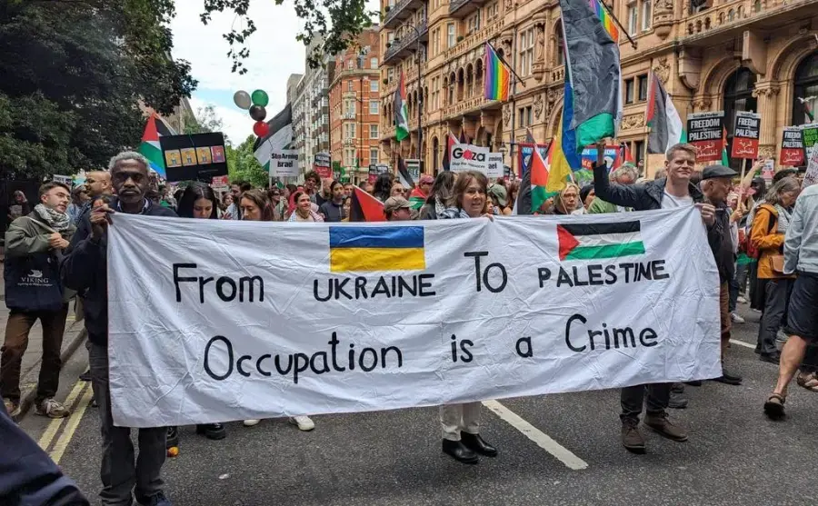 banner at london demonstration with text from ukraine to palestine occupation is a crime
